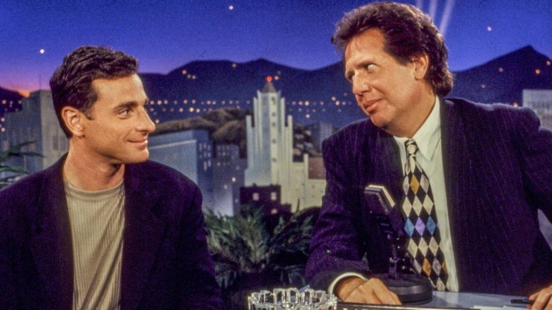 Bob Saget sitting across from Garry Shandling at a desk on the Larry Sanders Show