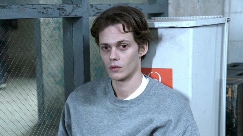 The Kid (Bill Skarsgård) sits impassively against a toxic waste container in Castle Rock