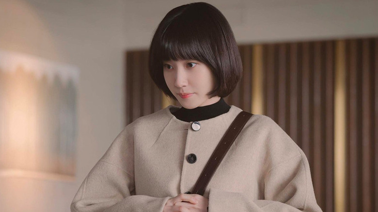 Woo Young-woo (Park Eun-bin) stands patiently in an office on Extraordinary Attorney Woo