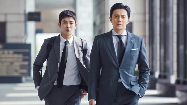 Go Yeon-woo (Park Hyung-sik) walks behind Choi Kang-seok (Jang Dong-gun) wearing a backpack on Suits (2018)