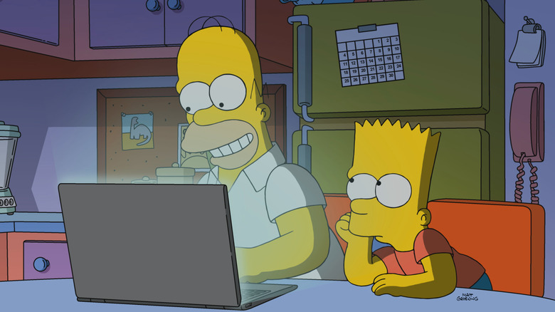 Homer and Bart Simpsons looking at a laptop on The Simpsons