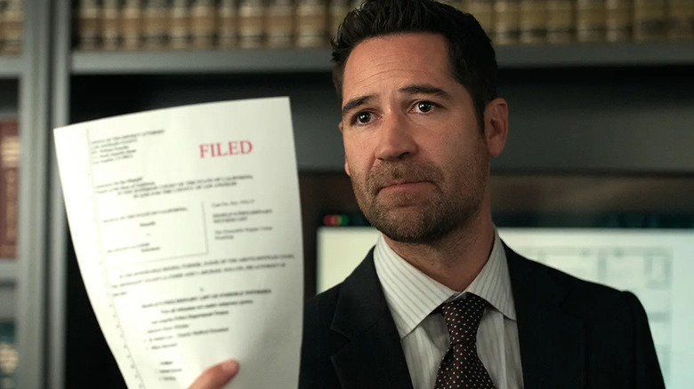 Mickey Haller (Manuel Garcia-Rulfo) holds up a legal document in The Lincoln Lawyer
