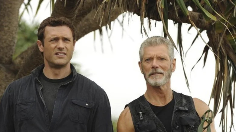 Jim Shannon (Jason O'Mara) stands next to Nathaniel Taylor (Stephen Lang) in a jungle in Terra Nova
