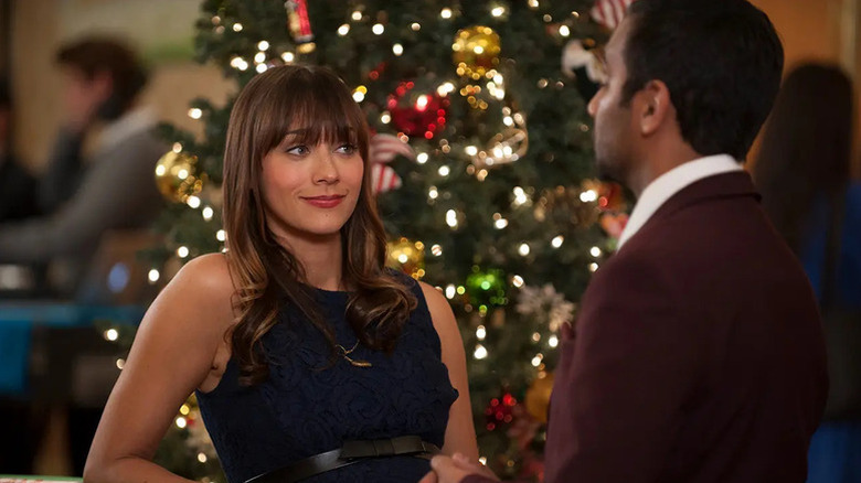 Ann Perkins (Rashida Jones) glances interestedly at Tom Haverford (Aziz Ansari) by a Christmas tree on Parks and Recreation