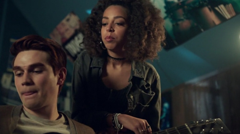 Valerie Brown (Hayley Law) stands over Archie Andrews (KJ Apa) holding her guitar in Riverdale