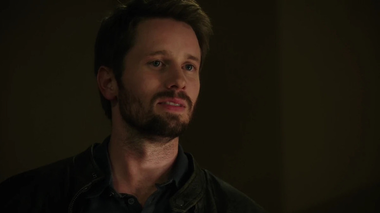 Billy Malone (Tyler Ritter) smirks in a darkened room in Arrow
