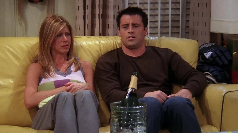 Rachel Green (Jennifer Aniston) and Joey Tribbiani (Matt LeBlanc) sit unhappily on a couch in Friends