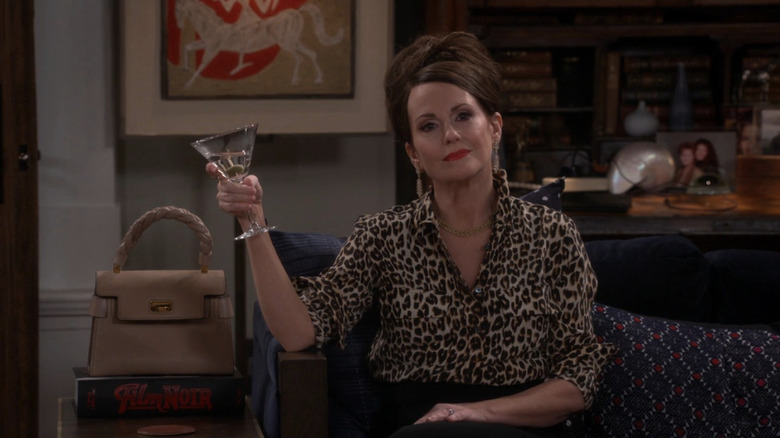 Megan Mullally as Karen with leopard print shirt holding martini and looking dazed in Will & Grace