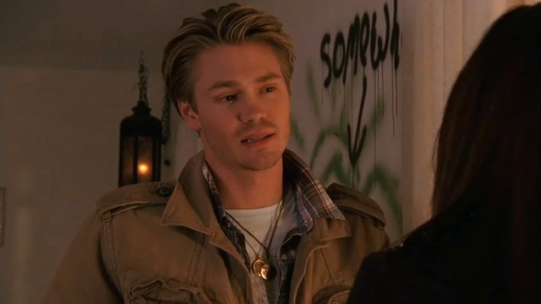 Lucas Scott (Chad Michael Murray) stands in a dimly lit room on One Tree Hill