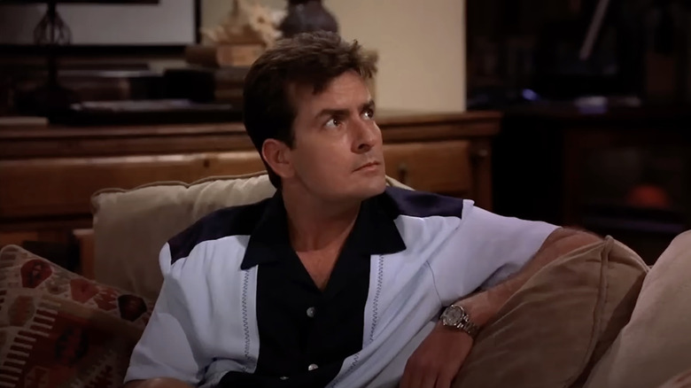Charlier Harper (Charlie Sheen) looks up from a couch on Two and a Half Men