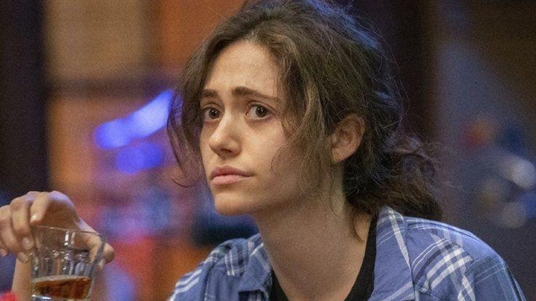 A disheveled Fiona Gallagher (Emmy Rossum) holds a glass of whiskey on Shameless