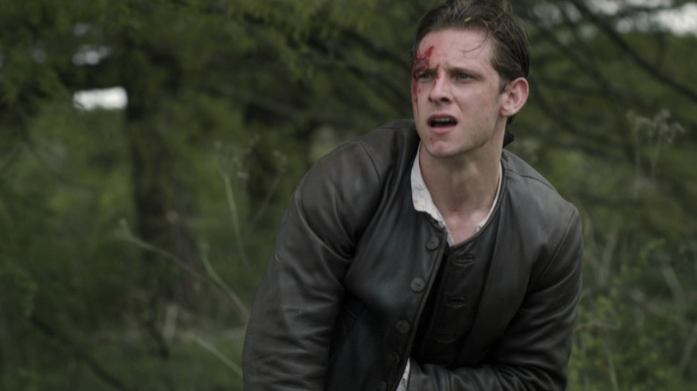 A bloodied Abraham Woodfull (Jamie Bell) looks up in a forest in Turn: Washington's Spies