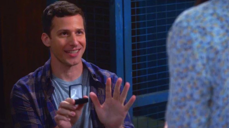 Jake Peralta (Andy Samberg) kneels displaying a ring in Brooklyn Nine-Nine
