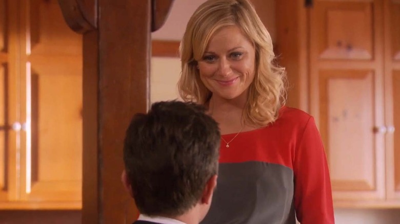 Leslie Knope (Amy Poehler) smiles emotionally as Ben Wyatt (Adam Scott) proposes to her