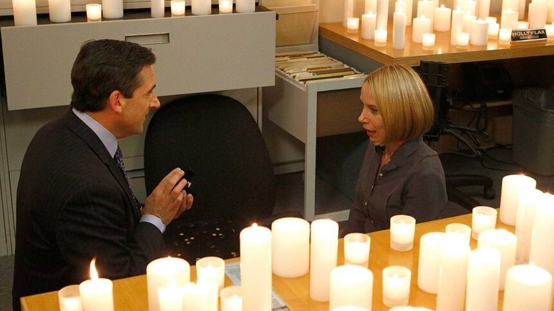 Holly Flax (Amy Ryan) gasps as Michael Scott (Steve Carell) shows her a ring in an office full of candles in The Office