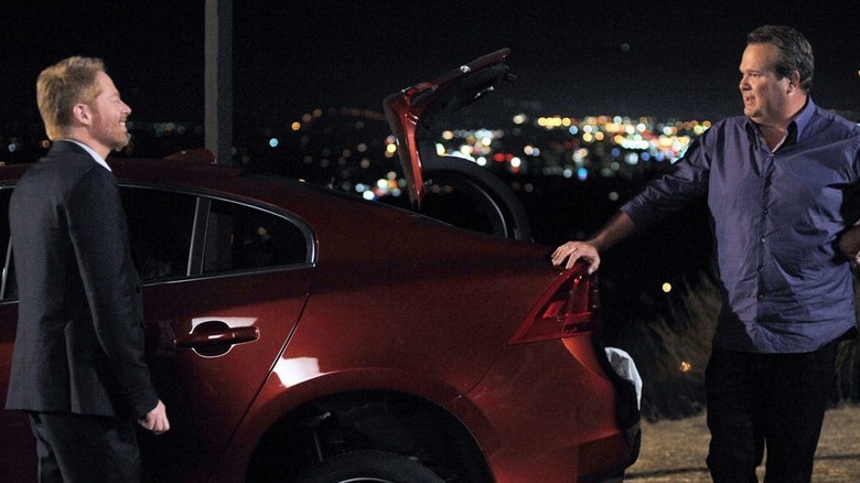 Mitch Pritchett (Jesse Tyler Ferguson) and Cam Tucker (Eric Stonestreet) stand by their car on the side of the road in Modern Family