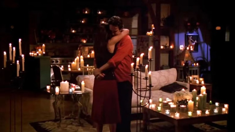 Monica Geller (Courteney Cox) and Chandler Bing (Matthew Perry) slow dance in an apartment full of candles in Friends