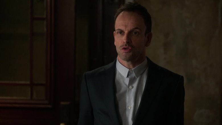 Sherlock Holmes (Jonny Lee Miller) discusses a case in Elementary
