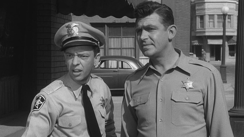Deputy Barney Fife (Don Knotts) and Sheriff Andy Taylor (Andy Griffith) examine a case in The Andy Griffith Show
