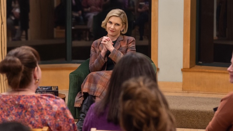 Rhea Seehorn as Carol Sturka smiling at a book reading in Pluribus