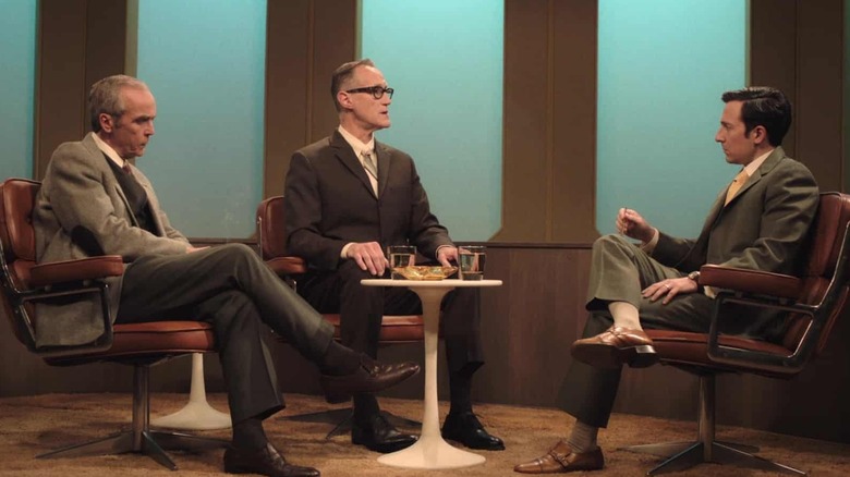 John Hannah, Christopher Heyerdahl, and Josh Brener sitting around a table in chairs as Neuman, Schoenheiss, and Murray in The Last of Us