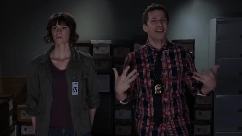 Devin Sidell and Andy Samberg as a victim and Jake Peralta standing together in Brooklyn Nine-Nine