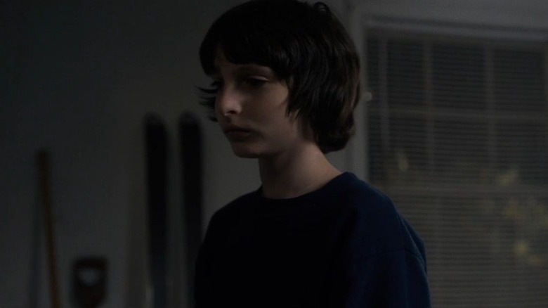 Finn Wolfhard as Mike standing in his garage in Stranger Things