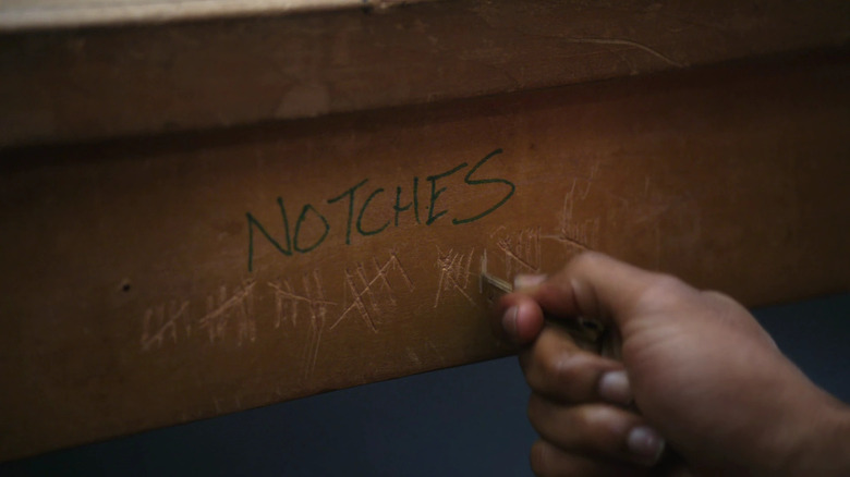 Donald Glover's hand as Troy making notches in the study table in Community