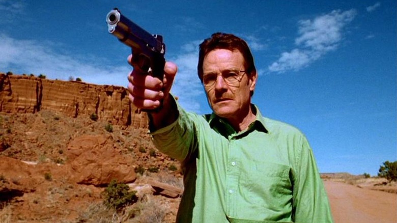 Bryan Cranston as Walter White holds a gun in the desert in Breaking Bad