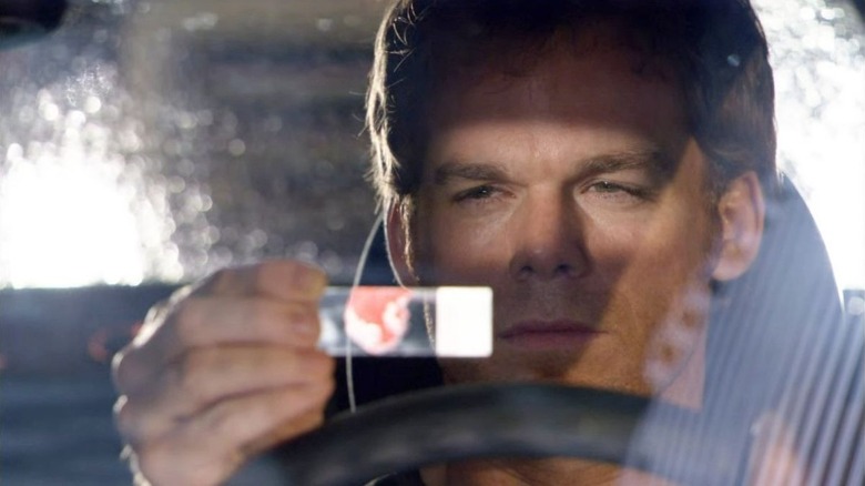 Michael C. Hall as Dexter Morgan, looking at a blood slide in Dexter.