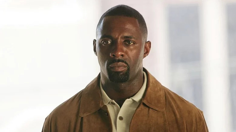 Idris Elba's Stringer Bell wearing a light brown jacket and looking serious on The Wire