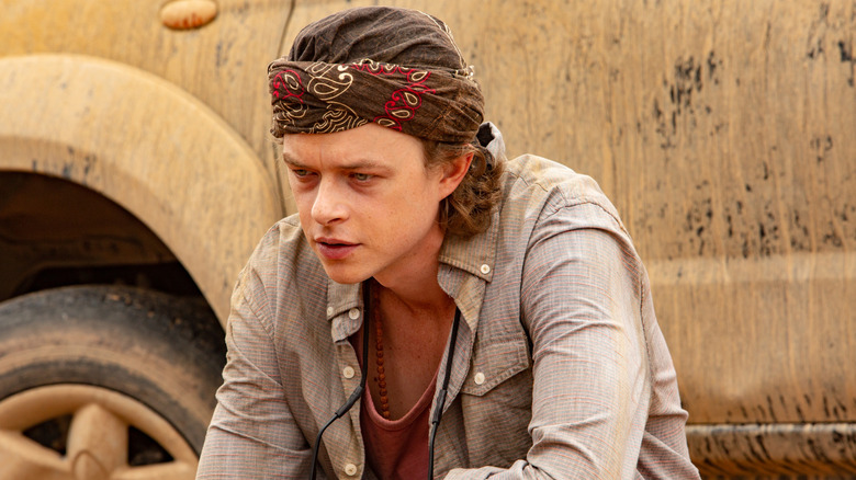 Dane DeHaan's Chris Lynwood sitting by a dirty car on ZeroZeroZero