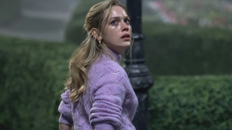 A sweaty Dani Clayton (Victoria Pedretti) looks away from a lamppost in The Haunting of Bly Manor