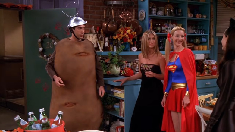 David Schwimmer as Ross, in costume as Spudnik, standing with Rachel, Phoebe as Supergirl, and Monica as Catwoman in Friends..