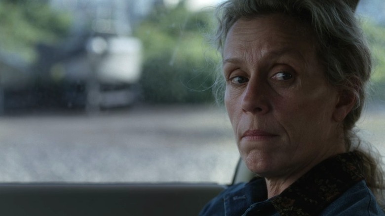 Olive sitting in the passenger's seat of a car and looking to her left on Olive Kitteridge S1E2
