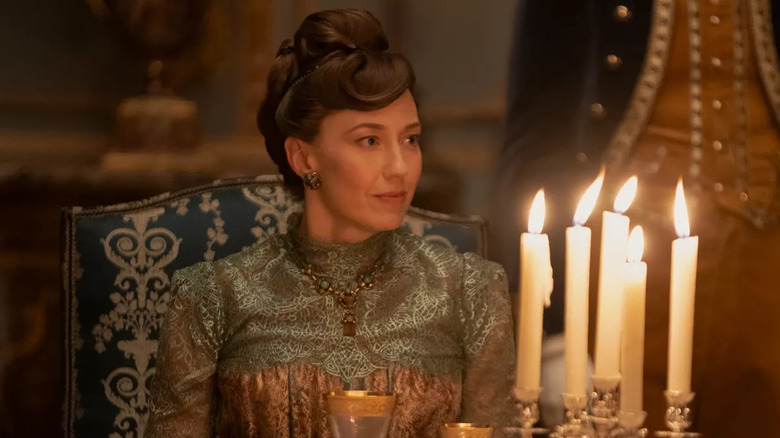 Bertha sitting at a dinner table in The Gilded Age