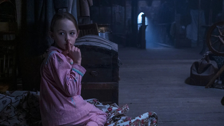 Flora (Amelie Bea Smith) sits in the attic in The Haunting of Bly Manor