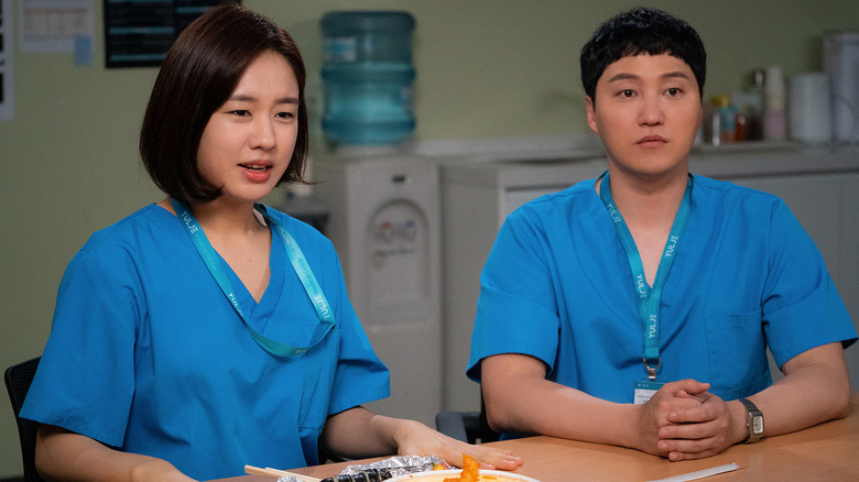 Chu Min-ha (Ahn Eun-jin) and Yang Seok-hyeong (Kim Dae-myung) sit at in a table in a hospital break room in Hospital Playlist