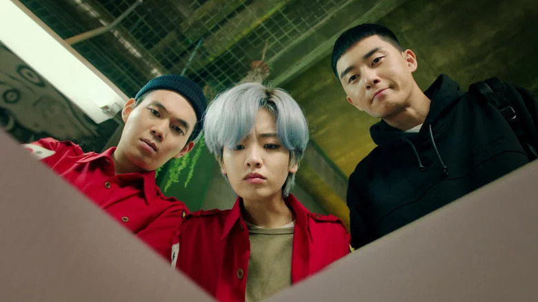 Choi Seung-kwon (Ryu Kyung-soo), Ma Hyun-yi (Lee Joo-young), and Park Sae-ro-yi (Park Seo-joon) look down into a box in Itaewon Class