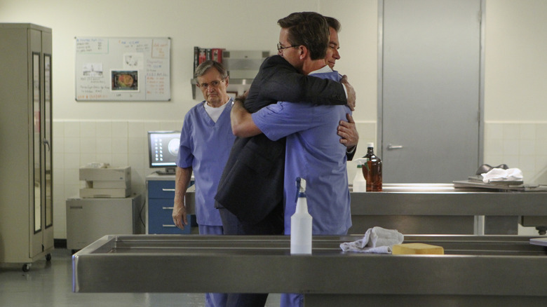 David McCallum's Ducky Mallard looks on as Michael Weatherly's Tony DiNozzo hugs Brian Dietzen's Jimmy Palmer on NCIS