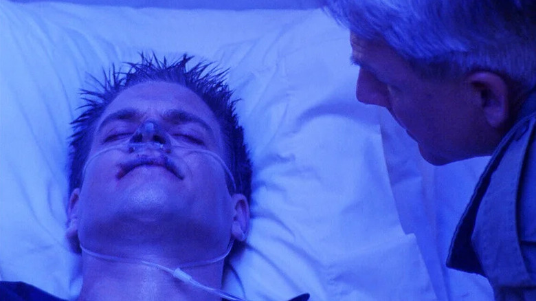 Michael Weatherly's Tony DiNozzo looking sick and wearing a breathig tube while Mark Harmon's Leroy Jethro Gibbs watches over him on NCIS