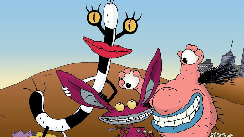 Ickis, Oblina, and Krumm smile outside a city in Aaahh!!! Real Monsters.