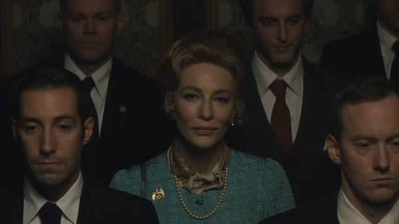 Cate Blanchett as Phyllis Schlafly, standing with several suited men in Mrs. America.