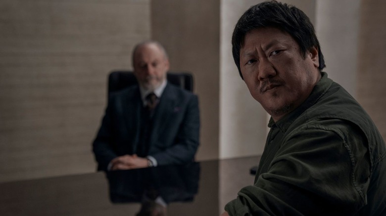 Da Shi (Benedict Wong) looks away from a man at a desk on 3 Body Problem