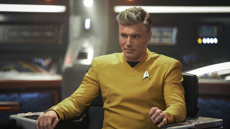 Christopher Pike (Anson Mount) smiles while sitting in the captain's chair in Star Trek: Strange New Worlds