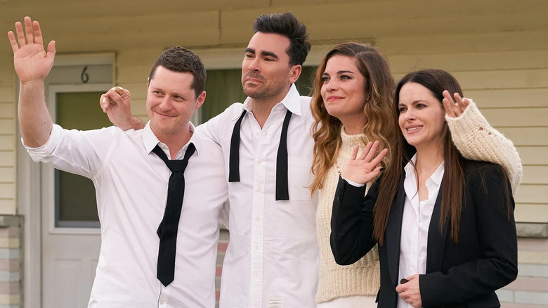 Patrick, David, Alexis, and Stevie, standing together outside a motel in Schitt's Creek.