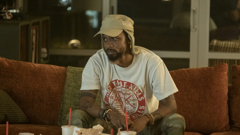 LaKeith Stanfield as Darius, watching TV and eating Popeyes in Atlanta.
