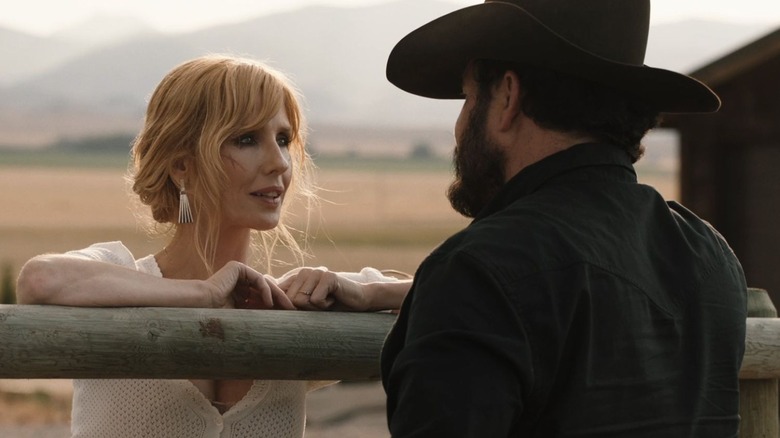 Kelly Reilly as Beth Dutton and Cole Hauser as Rip Wheeler, talking over a fence in Yellowstone.