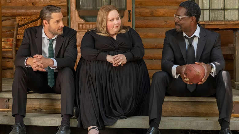 Justin Hartley, Chrissy Metz, and Sterling K. Brown as Kevin, Kate, and Randall Pearson, sitting on a stoop in funeral wear in This Is Us.