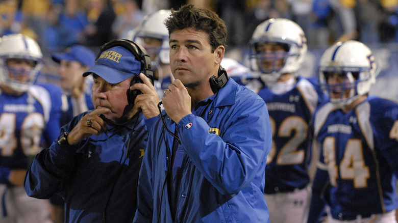 Kyle Chander as Coach Taylor standing in front of some football players in Friday Night Lights